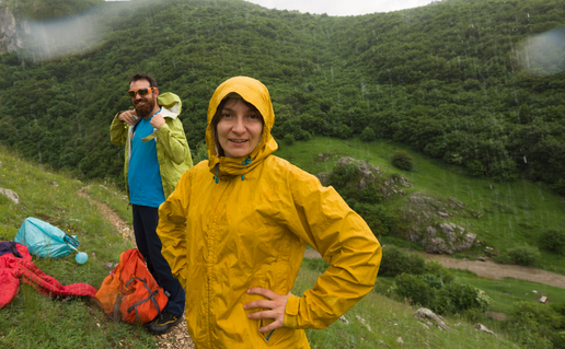 Woman and man wearing waterproofs standing in the rain in the hills